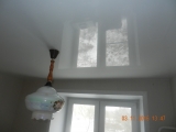 Установлен белый глянцевый потолок с люстрой на кухне, установлена декоративная вставка по периметру в цвет потолка.